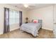 Comfortable bedroom featuring a ceiling fan, large windows with curtains, and carpeted flooring at 1006 Apogee Dr, Indian Trail, NC 28079