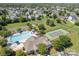 Aerial view of community clubhouse featuring a pool, playground, tennis court, and green lawns at 1006 Apogee Dr, Indian Trail, NC 28079