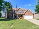 Traditional two-story brick home with a spacious front yard, complemented by mature trees at 1006 Apogee Dr, Indian Trail, NC 28079