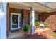 Inviting covered front porch with rocking chairs, greenery and brick facade at 1006 Apogee Dr, Indian Trail, NC 28079