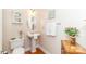 Charming half bathroom with a pedestal sink, decorative mirror, and wood-look floors at 1006 Apogee Dr, Indian Trail, NC 28079