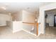 Upstairs hallway with carpet flooring, wooden banister, neutral paint color and view to the game room at 1006 Apogee Dr, Indian Trail, NC 28079