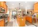 Open-concept kitchen with island, stainless appliances, and a breakfast nook with backyard view at 1006 Apogee Dr, Indian Trail, NC 28079