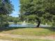 Beautiful view of community pond featuring a fountain, mature trees, and a picturesque green landscape at 1006 Apogee Dr, Indian Trail, NC 28079