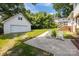 Backyard featuring detached garage, lush greenery, and outdoor seating area with chairs at 1013 Eaglewood Ave, Charlotte, NC 28212