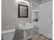 Bathroom with pedestal sink, toilet, and open doorway at 1013 Eaglewood Ave, Charlotte, NC 28212