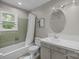 Bathroom featuring green tiled shower-tub combination, vanity, lighting, and window at 1013 Eaglewood Ave, Charlotte, NC 28212