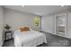 Cozy bedroom features a neutral color palette, closet, and a sunny window view at 1013 Eaglewood Ave, Charlotte, NC 28212