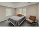 This bedroom offers two windows, grey carpet, and warm, neutral paint at 1013 Eaglewood Ave, Charlotte, NC 28212
