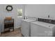 Functional laundry room includes white washer and dryer units and natural light at 1013 Eaglewood Ave, Charlotte, NC 28212