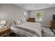 Well-lit bedroom featuring carpeted floors, neutral walls, and two windows at 1013 Eaglewood Ave, Charlotte, NC 28212