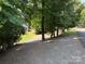Gravel yard with trees and partial view of home at 104 Deer Park Rd # D143, Mount Gilead, NC 27306