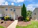 Exterior view of townhomes with mulched landscaping and green grass at 10446 Trolley Run Dr, Cornelius, NC 28031