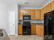 Kitchen includes wooden cabinets and black appliances at 10446 Trolley Run Dr, Cornelius, NC 28031