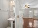Cozy powder room with a pedestal sink and a view into the living room, offering convenience for guests at 10446 Trolley Run Dr, Cornelius, NC 28031
