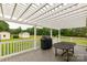 Outdoor deck with a pergola, grill, and table, overlooking a spacious green lawn and outbuildings at 1162 E Doc Garris Rd, Lancaster, SC 29720