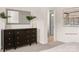 Cozy bedroom featuring a dark wood dresser, a large mirror, and access to the bathroom at 12016 Basking Dr, Charlotte, NC 28214