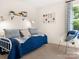 Bright bedroom featuring a comfortable daybed, a cozy chair, and a large window at 12016 Basking Dr, Charlotte, NC 28214