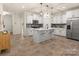 Well-appointed kitchen featuring white cabinets, stainless appliances, and center island seating at 12016 Basking Dr, Charlotte, NC 28214