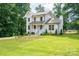 Two-story home nestled among trees, featuring a welcoming front porch and well-manicured lawn at 1256 Canseco Ln, Hickory, NC 28602