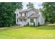 Two-story home with a charming front porch, surrounded by lush trees and a well-maintained lawn at 1256 Canseco Ln, Hickory, NC 28602