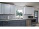 Charming kitchen featuring white upper cabinets, gray lower cabinets, marble backsplash, and modern stainless steel appliances at 1256 Canseco Ln, Hickory, NC 28602