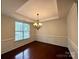 Elegant dining room featuring a tray ceiling, hardwood floors, wainscoting, and a stylish chandelier at 1304 Ridge Haven Rd, Waxhaw, NC 28173