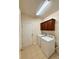 Bright laundry room with white washer and dryer, overhead cabinets and tile flooring at 1304 Ridge Haven Rd, Waxhaw, NC 28173