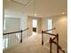 Open loft area with wood railing and neutral carpet leading to bathrooms and bedrooms at 1304 Ridge Haven Rd, Waxhaw, NC 28173