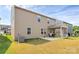 Rear view of the home showcasing the covered patio, spacious backyard, and neutral siding at 13140 Sudwick Ln, Charlotte, NC 28278