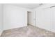 This bedroom has neutral carpet, white walls, and a double closet at 13140 Sudwick Ln, Charlotte, NC 28278