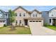 Charming tan two-story home featuring a two-car garage, landscaped yard, and inviting front entrance at 13140 Sudwick Ln, Charlotte, NC 28278