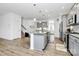 Open kitchen with a large island, stainless steel appliances, and access to the staircase at 13140 Sudwick Ln, Charlotte, NC 28278