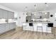 Modern kitchen featuring grey cabinets, stainless steel appliances, and a spacious island with bar seating at 13140 Sudwick Ln, Charlotte, NC 28278
