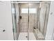 A modern shower stall featuring tile walls, glass doors, and built-in shelving at 13140 Sudwick Ln, Charlotte, NC 28278