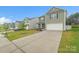 View of a two-story home featuring a long driveway, attached garage and freshly cut lawn in a neighborhood at 1323 Mifflin Ln, Dallas, NC 28034
