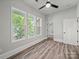 Three large windows provide backyard views in this light and airy bedroom with modern ceiling fan at 144 Walnut St, Chester, SC 29706