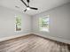 A spacious bedroom features wood-look floors, neutral walls, a modern ceiling fan, and two windows at 144 Walnut St, Chester, SC 29706