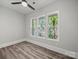 This bright bedroom has three windows, wood-look flooring, neutral walls, and a ceiling fan for comfort at 144 Walnut St, Chester, SC 29706
