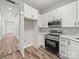 Modern kitchen features white cabinets, stainless steel appliances, and wood-look flooring at 144 Walnut St, Chester, SC 29706