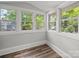 A sunroom boasts ample natural light from an array of windows and warm flooring throughout at 144 Walnut St, Chester, SC 29706