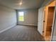 A bedroom features gray walls, carpet, and a window letting in natural light, next to doorway to a full bath at 1459 Mocksville Hwy # 19, Statesville, NC 28625