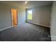 A well-lit bedroom with neutral walls, plush carpeting, and a large window and doorway for natural light exposure at 1459 Mocksville Hwy # 19, Statesville, NC 28625