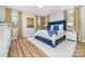 Well-lit bedroom with a blue upholstered bed frame, white nightstands, and elegant draperies at 148 Powder Spring Dr, Statesville, NC 28677