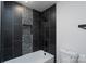 A modern bathroom features a white bathtub, a pebble tile inset, and black tile surround at 1528 Enochville Rd, Kannapolis, NC 28081