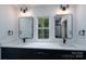 Stylish bathroom boasts dual sinks, quartz countertop, black fixtures, and a bright window with a wooded view at 1528 Enochville Rd, Kannapolis, NC 28081