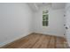 Bedroom features a modern design with hardwood flooring, white walls, and black door hardware at 1528 Enochville Rd, Kannapolis, NC 28081