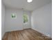 A bright bedroom featuring wood floors, two windows, and white walls, creating a modern and inviting space at 1528 Enochville Rd, Kannapolis, NC 28081