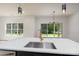 Kitchen island with white countertops and golden faucet offering views of backyard at 1528 Enochville Rd, Kannapolis, NC 28081