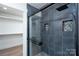 Modern shower with black hardware, gray tile, river rock detail, and a glass enclosure offers luxury bathing at 1528 Enochville Rd, Kannapolis, NC 28081